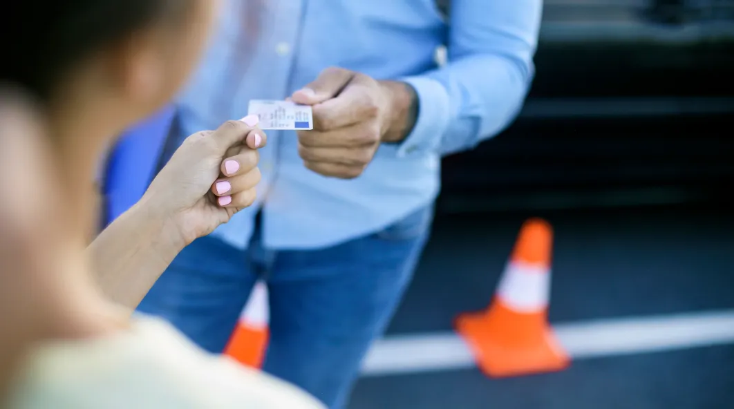 hands passing an ID