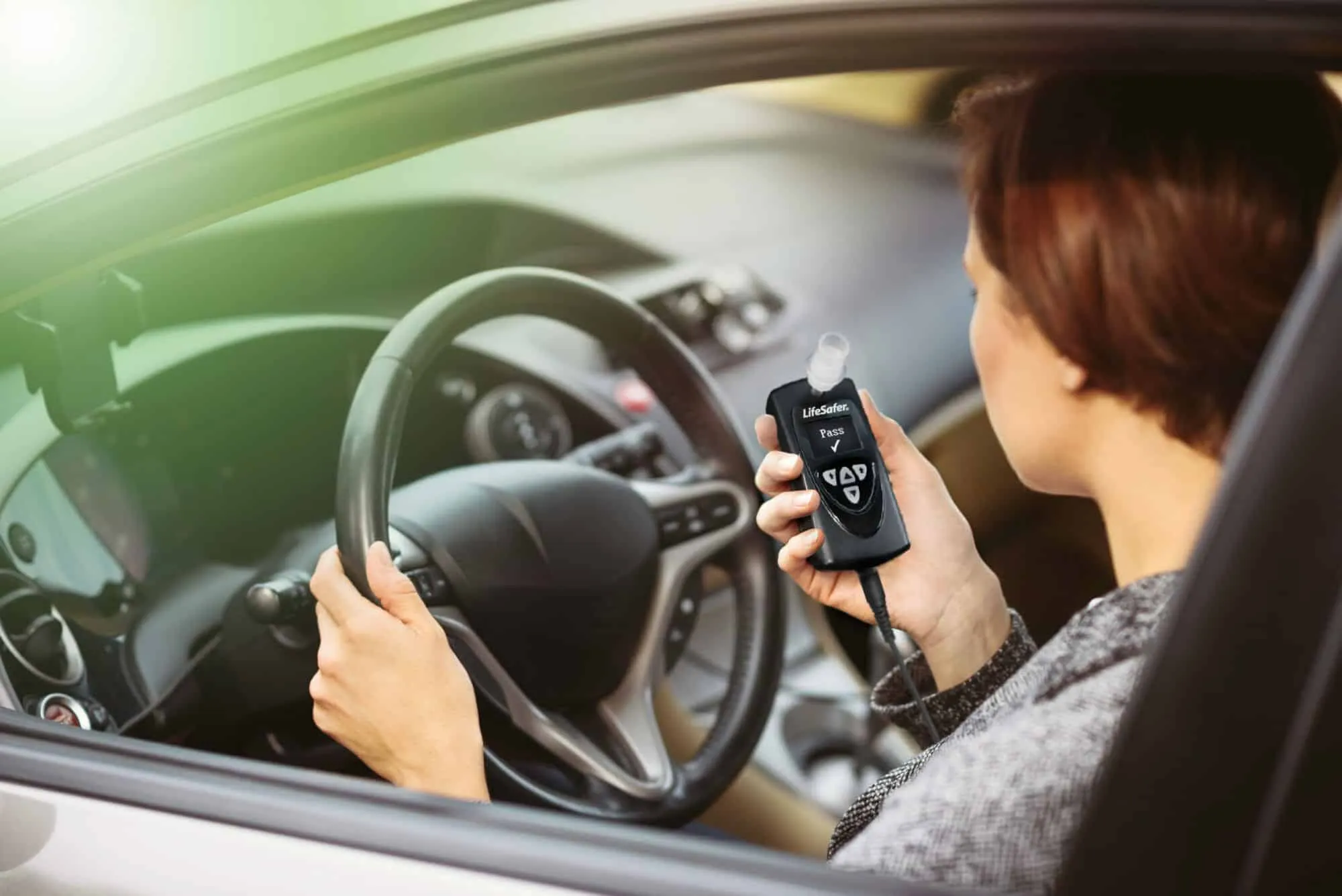 Woman about to use a LifeSafer L250 interlock device in her car