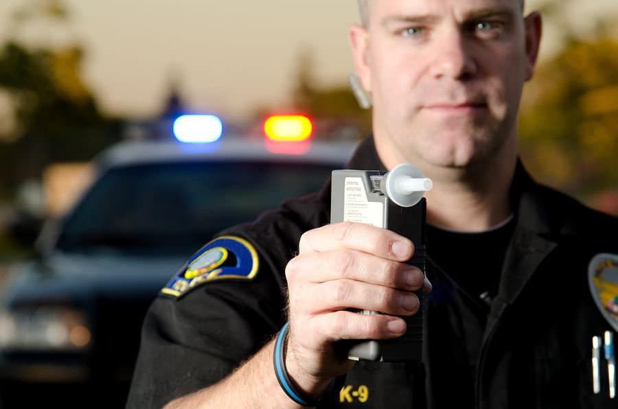 Police officer holding breathalyzer test