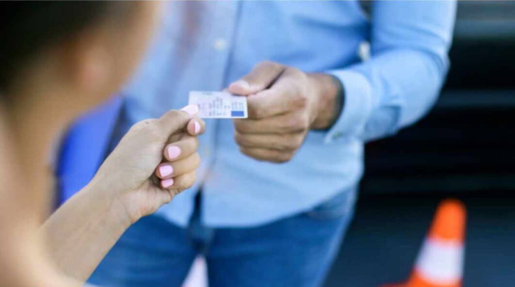 Woman handing driving licence to man