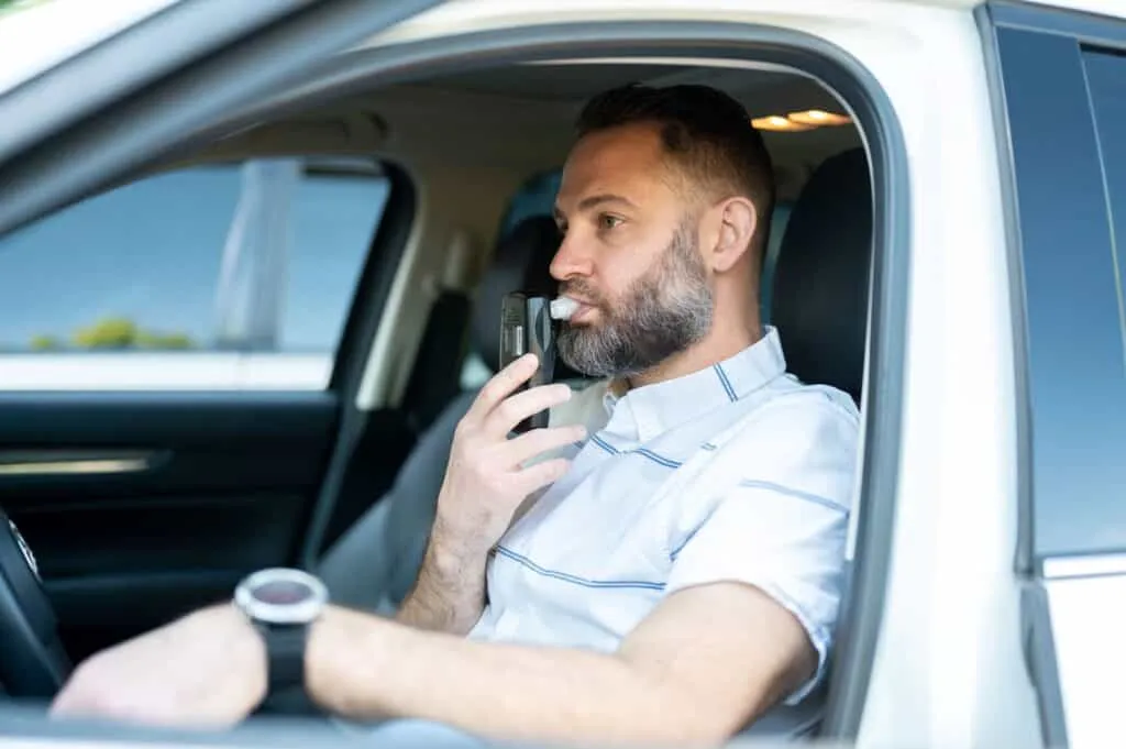 Person blowing into a LifeSafer Ignition Interlock Device.